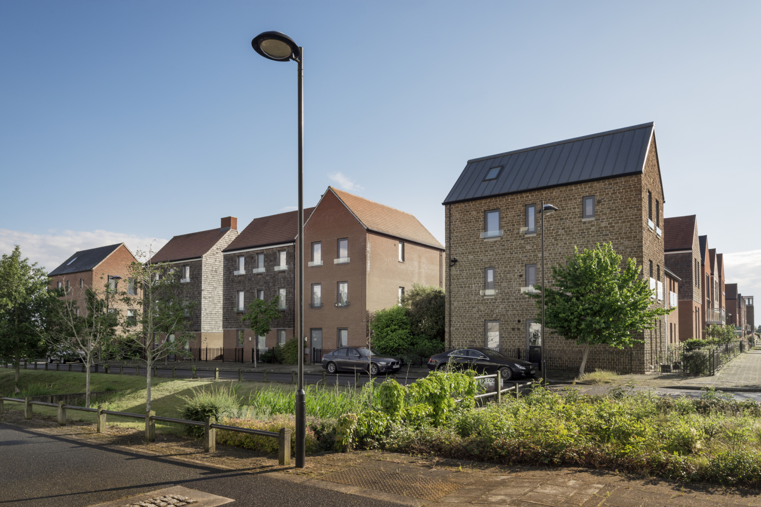 View of houses along the green Sustainable Urban Drainage Systems (SUDS)